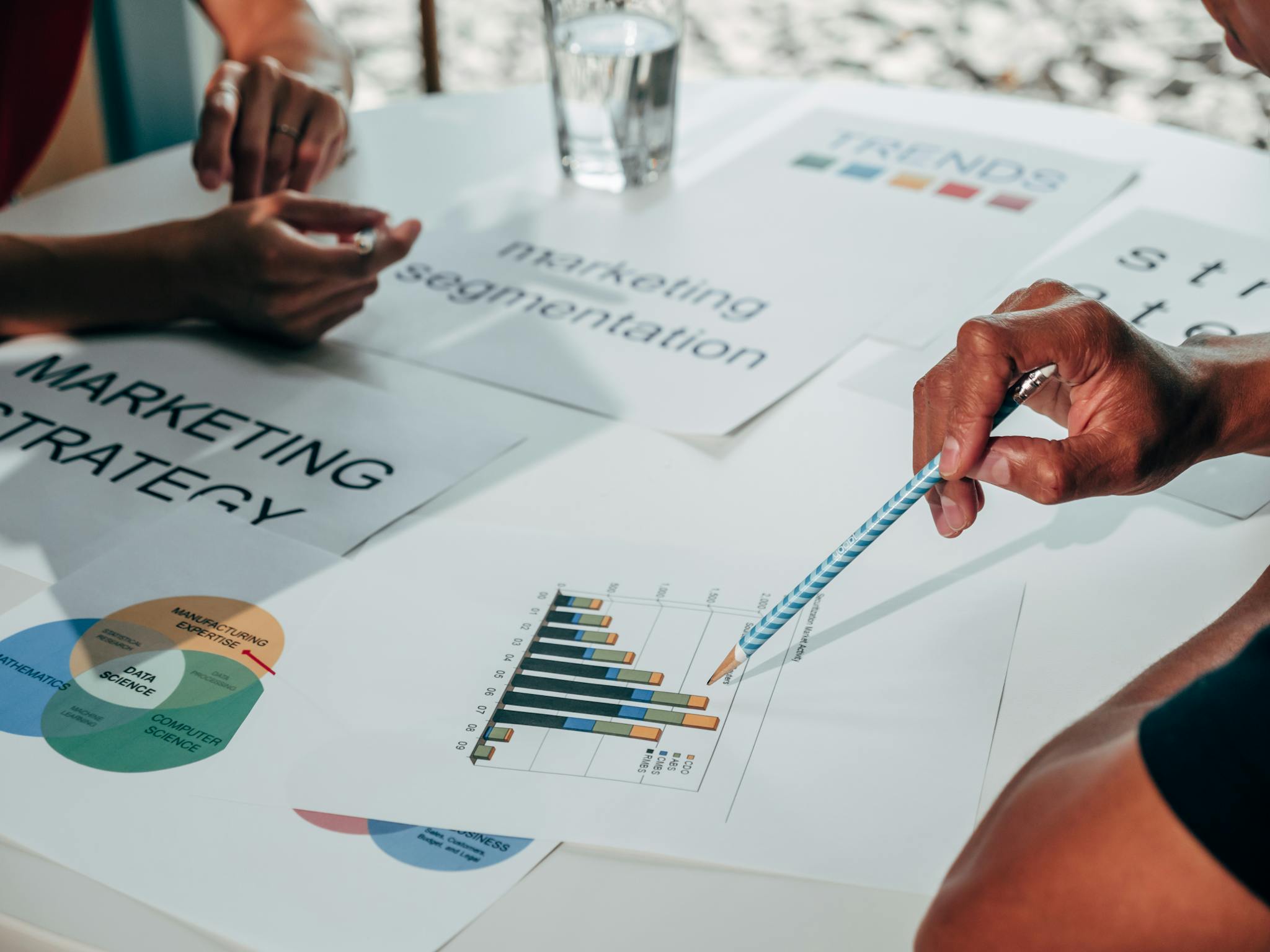 Home Team working on marketing strategy using data charts and papers in an office meeting.